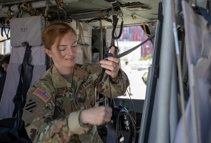 2nd Lt. Valdeta Mehanja, a pilot with the 1-131st Aviation Regiment, checks the safety harnesses in a UH-60 Black Hawk helicopter after landing in Mother Teresa Square in Albania May 22, 2021. Mehanja has been flying Black Hawks for the Alabama National Guard since 2019.