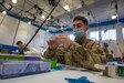 Pennsylvania Air National Guard Senior Airman Benedict Barnett, a medic with the 193d Special Operations Wing, prepares band-aids at the Esperanza Community Vaccination Center. The center is a partnership between the Federal Emergency Management Agency (FEMA), the City of Philadelphia and the Commonwealth of Pennsylvania., in Philadelphia, April 8, 2021.