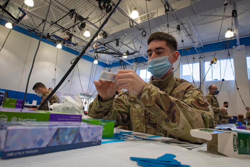 Pennsylvania Air National Guard Senior Airman Benedict Barnett, a medic with the 193d Special Operations Wing, prepares band-aids at the Esperanza Community Vaccination Center. The center is a partnership between the Federal Emergency Management Agency (FEMA), the City of Philadelphia and the Commonwealth of Pennsylvania., in Philadelphia, April 8, 2021.