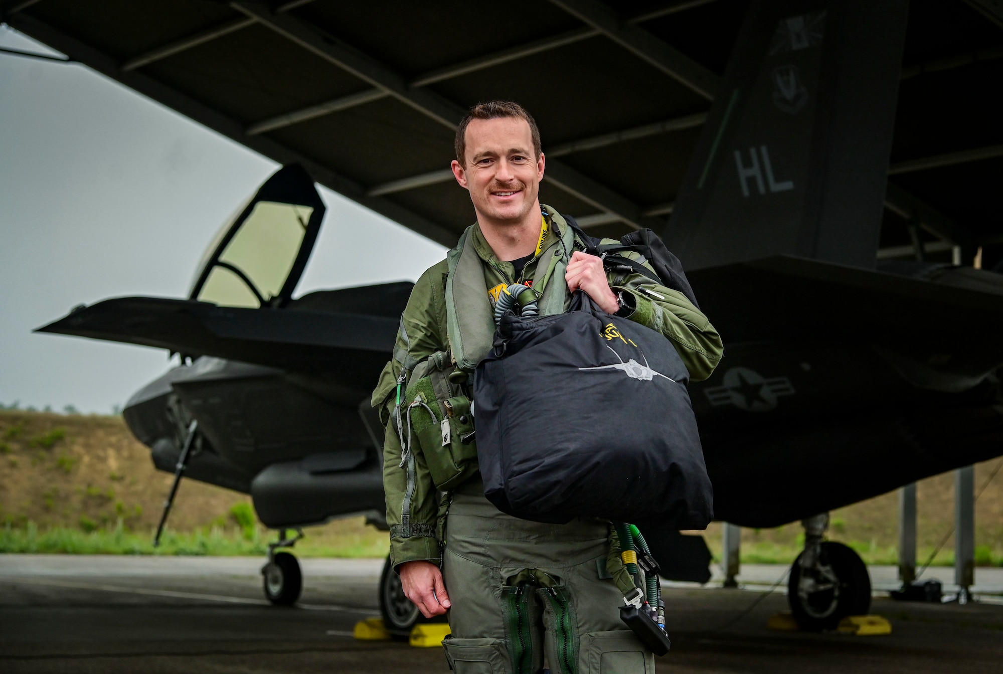 Pilot in a flight suit standing in front of an aircraft