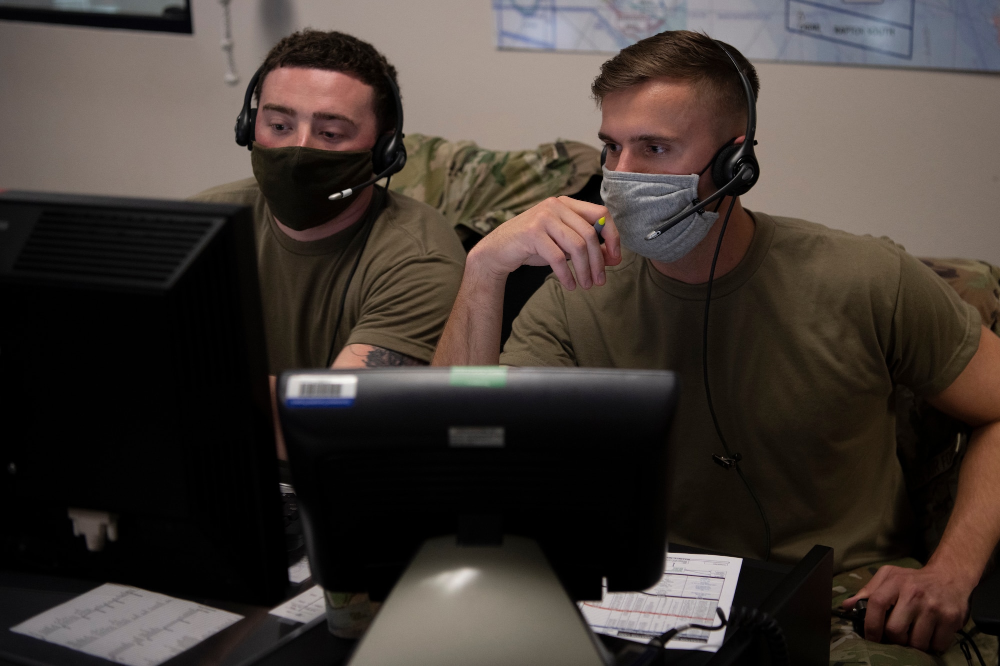 Two men sit at a computer