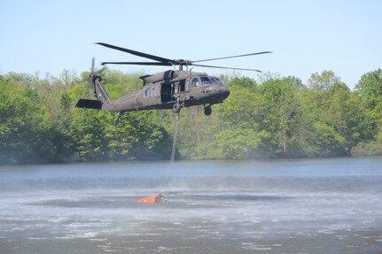 One CH-47 Chinook and two UH-60 Black Hawk helicopters conduct water bucket firefighter training May 11, 2021, at Memorial Lake State Park and Fort Indiantown Gap, Pennsylvania. The Pennsylvania National Guard crews take water from Memorial Lake and drop it in Fort Indiantown Gap’s training corridor.