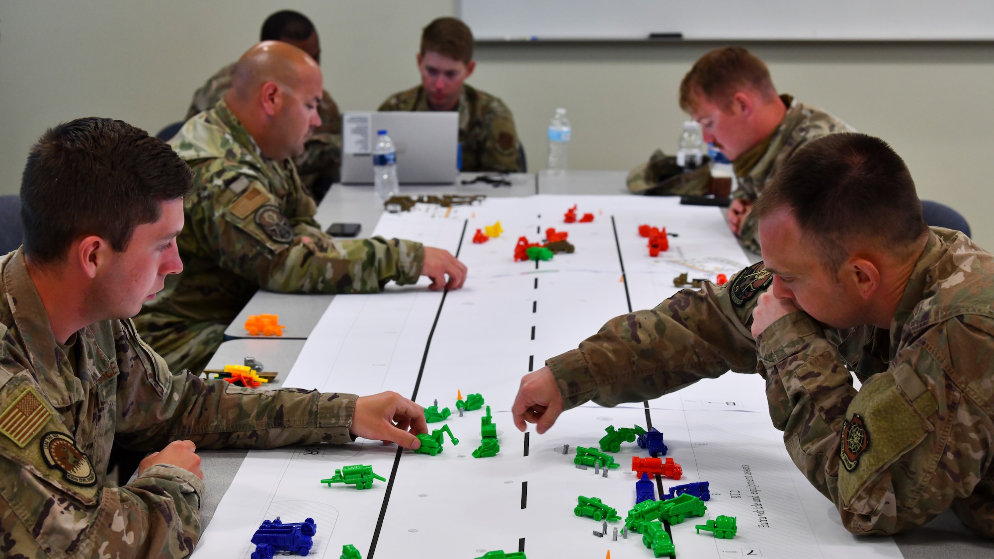 Civil engineering Airmen evaluate where to place their assets on a replica of a damaged flightline for a tabletop exercise during Exercise Mobility Guardian 2021 at Alpena Combat Readiness Training Center, Mich., May 22, 2021. Mobility Guardian is the Air Force's largest and longest exercise ensuring readiness to move personnel and equipment in combat operations. (U.S. Air Force photo by Tech. Sgt. Kentavist P. Brackin)