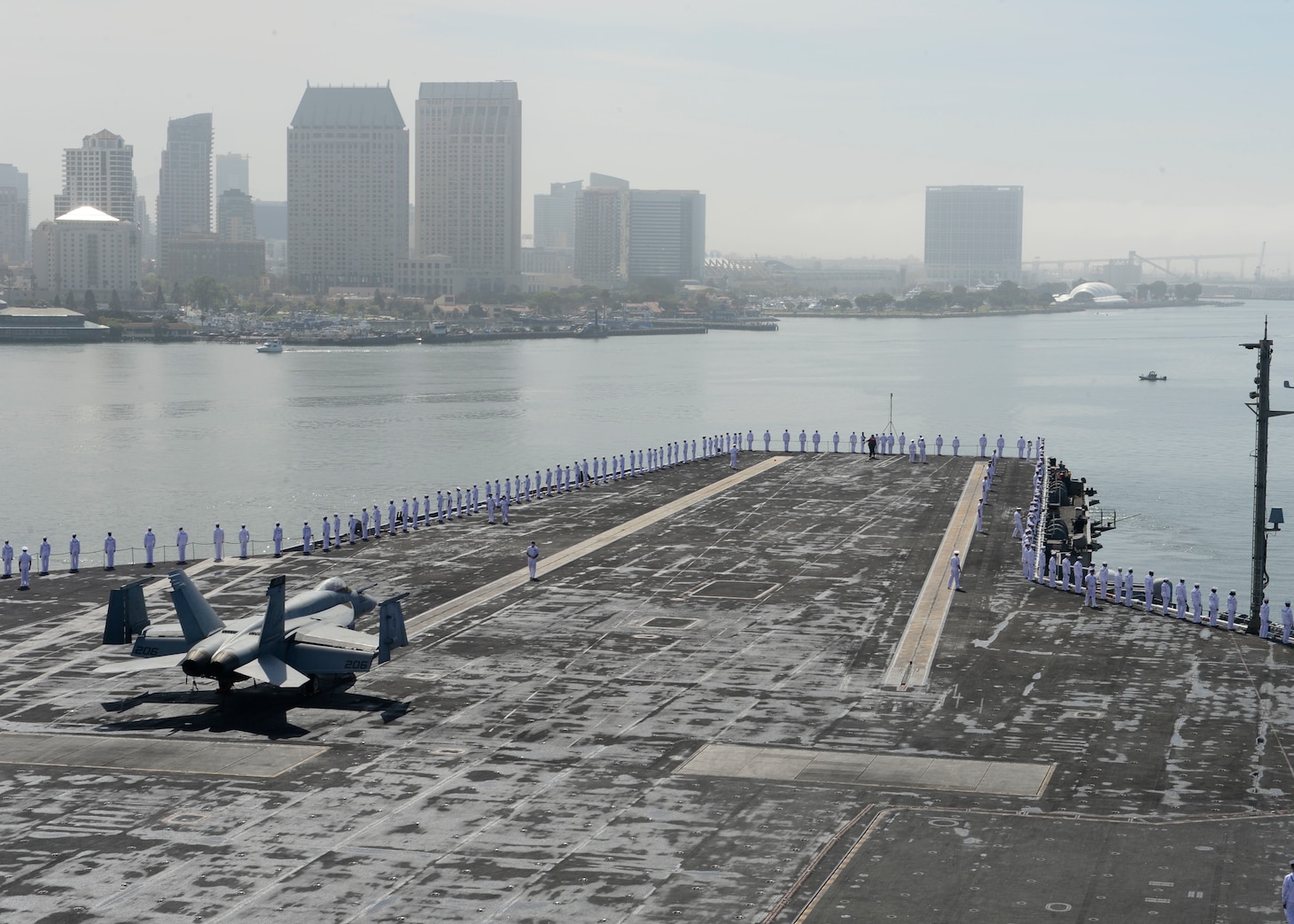 Sailors man the rails aboard the Nimitz-class aircraft carrier USS Theodore Roosevelt (CVN 71).