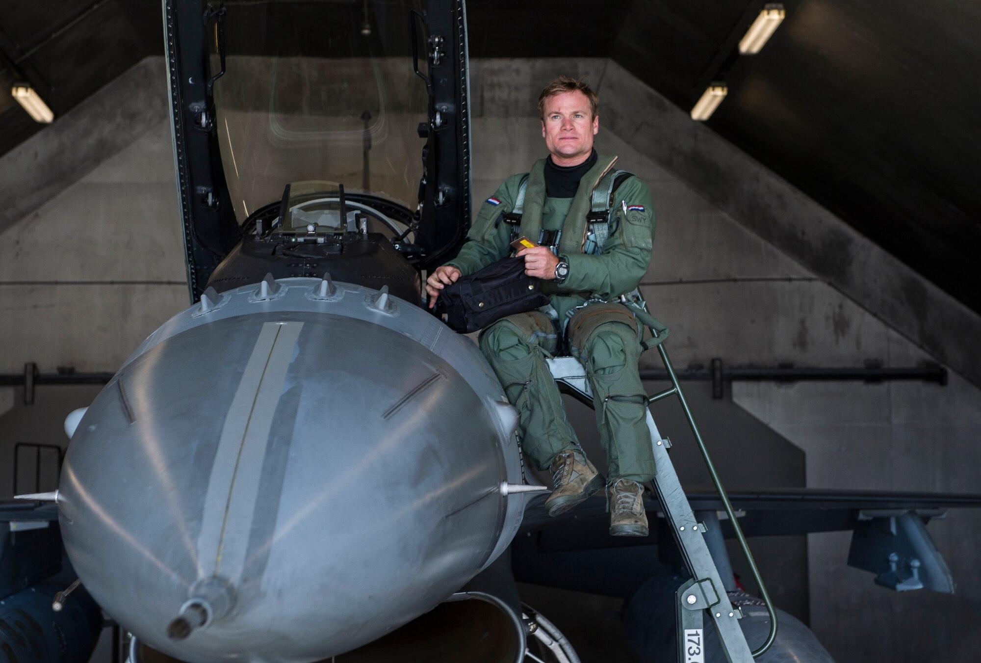 U.S. Air Force Exchange Pilot Maj. Kevin Sweeney climbs out of an F-16 Falcon at Leeuwarden Air Base, Netherlands, March 27, 2017 during the NATO air forces' Frisian Flag training exercise. Nearly 300 U.S. Airmen and 12 F15C Eagles of the 122nd Expeditionary Fighter Squadron participated in training alongside NATO allies to strengthen interoperability and demonstrate U.S. commitment to the security and stability of Europe. During Frisian Flag, NATO air forces conducted air defense missions, offensive missions, missions to protect other aircraft and missions carried out to eliminate static and dynamic targets on land or at sea. (U.S. Air Force Photo/Master Sgt. Brian Ferguson)