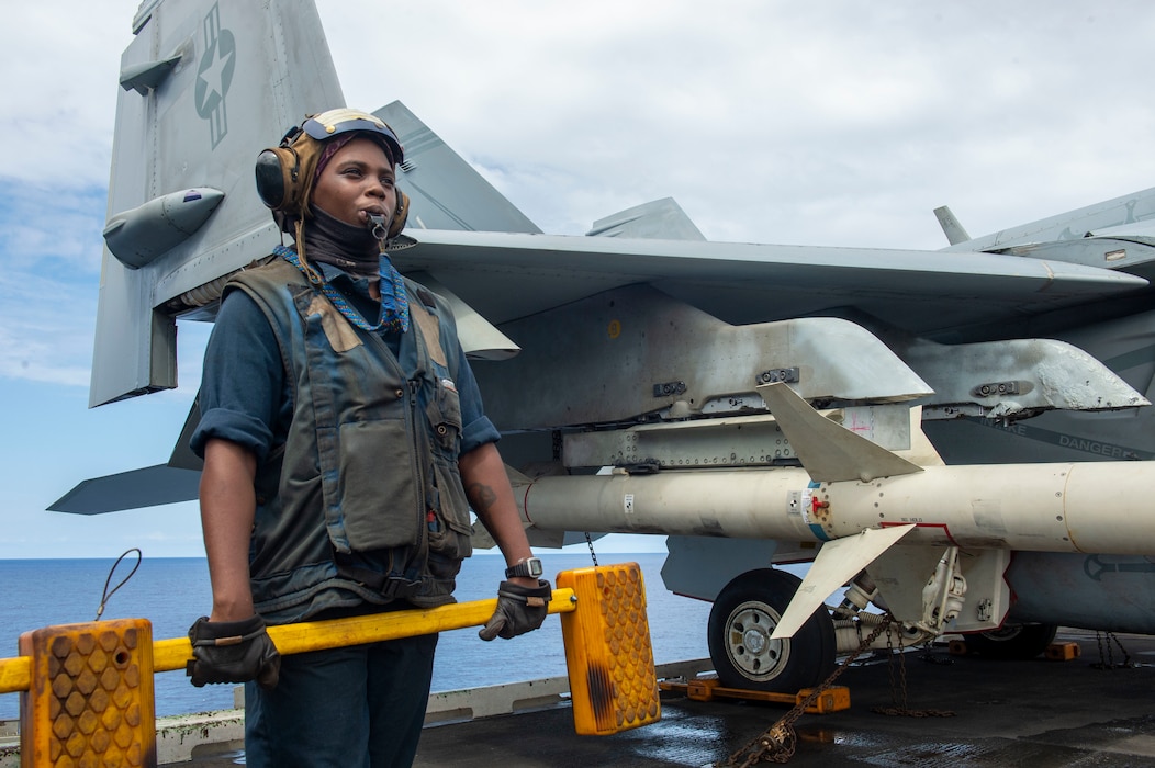 Aviation Boatswain’s Mate (Handling) Airman Apprentice Patricia Ramos, from Detroit prepares to chock an F/A-18 Super Hornet aboard the Nimitz-class aircraft carrier USS Dwight D. Eisenhower (CVN 69).