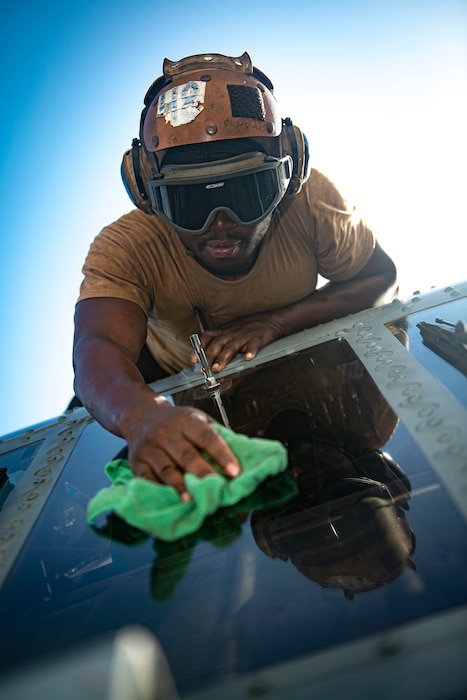 Aviation Structural Mechanic Airman Dujon Samuel cleans the window of a an MH-60R Sea Hawk, attached to the "Swamp Foxes" of Helicopter Maritime Strike Squadron 74,  aboard the aircraft carrier USS Dwight D. Eisenhower (CVN 69) May 20, 2020