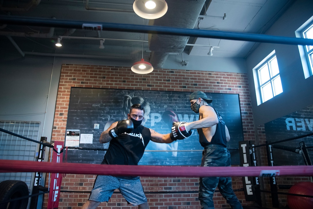 Service member spars in boxing ring.