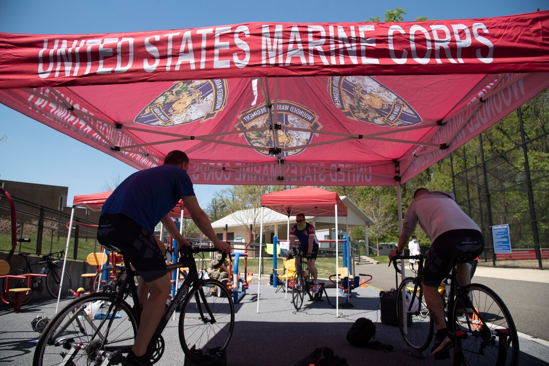 U.S. Marines cycle on trainers under tent.