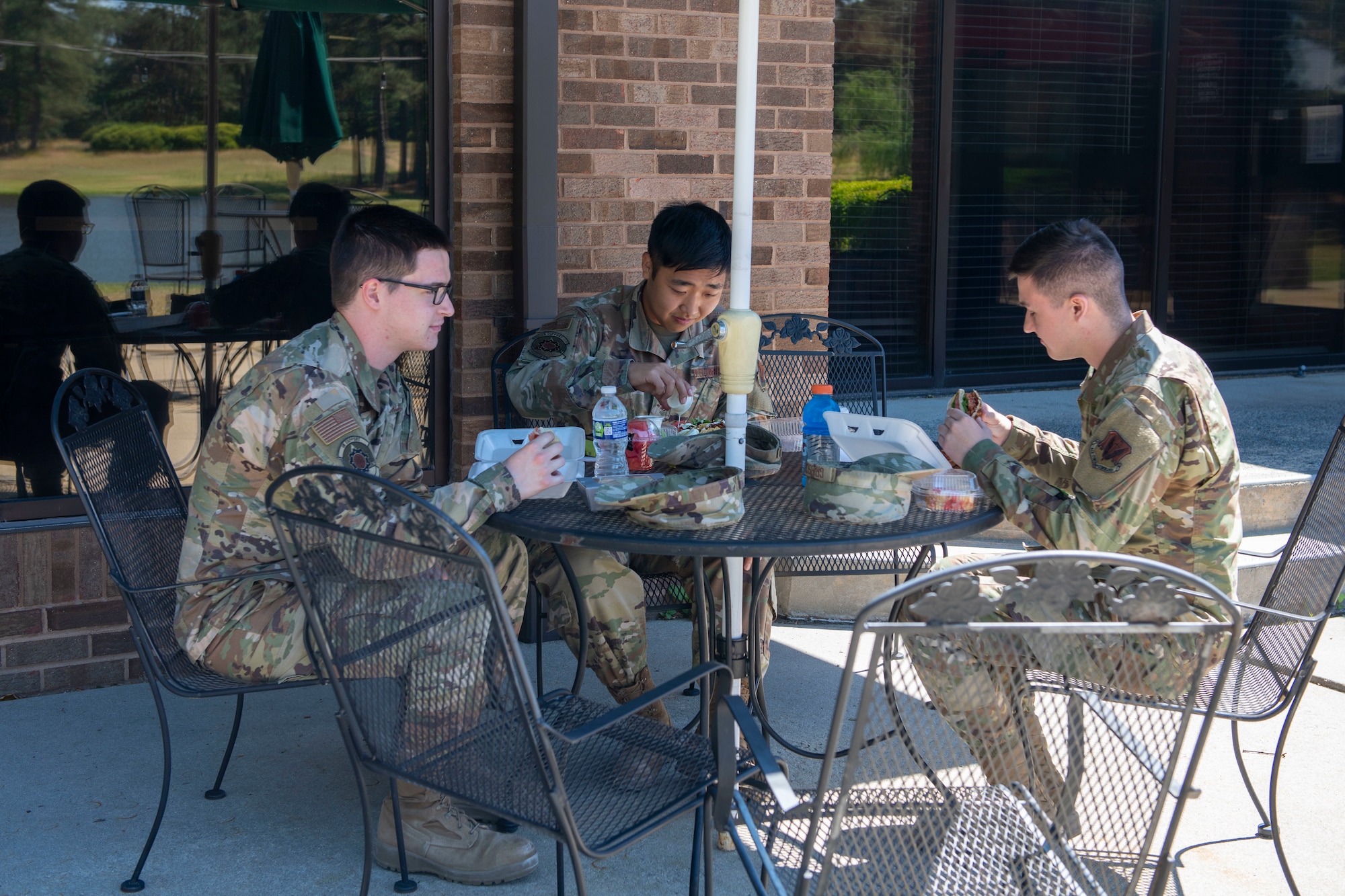Avionics technicians from the 4th Component Maintenance Squadron eat lunch on the outdoor patio of the Compass Café at Seymour Johnson Air Force Base, North Carolina, May 13, 2021.