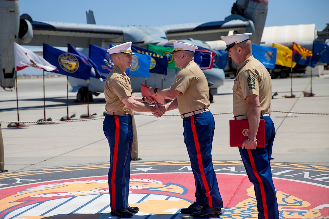 U.S. Marine Corps Col. Chuck Dudik, commanding officer of Marine Corps Air Station Yuma, presents the Legion of Merit to Lt. Col. Olgierd J. Weiss III during a retirement ceremony on the flight line, May 21, 2021.