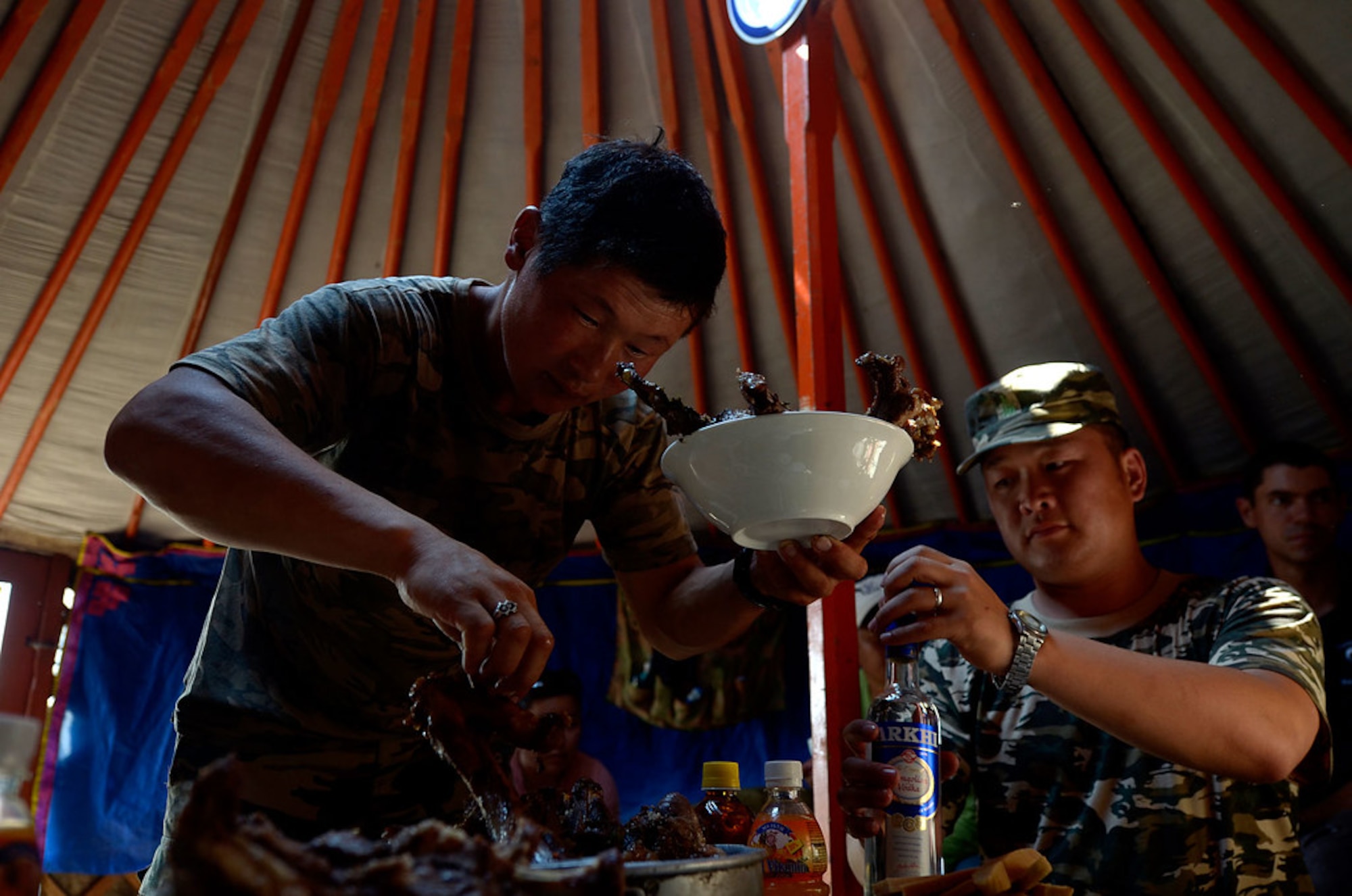 A couple of Mongolian Border Forces cut and prepare some mutton for lunch. Mongolians' diet relies heavily on meat and dairy products, The meat-dependent diet arises from the need for hearty food to stave off the cold and long winters.(U.S. Air Force photo/Master Sgt. Jeremy T. Lock)