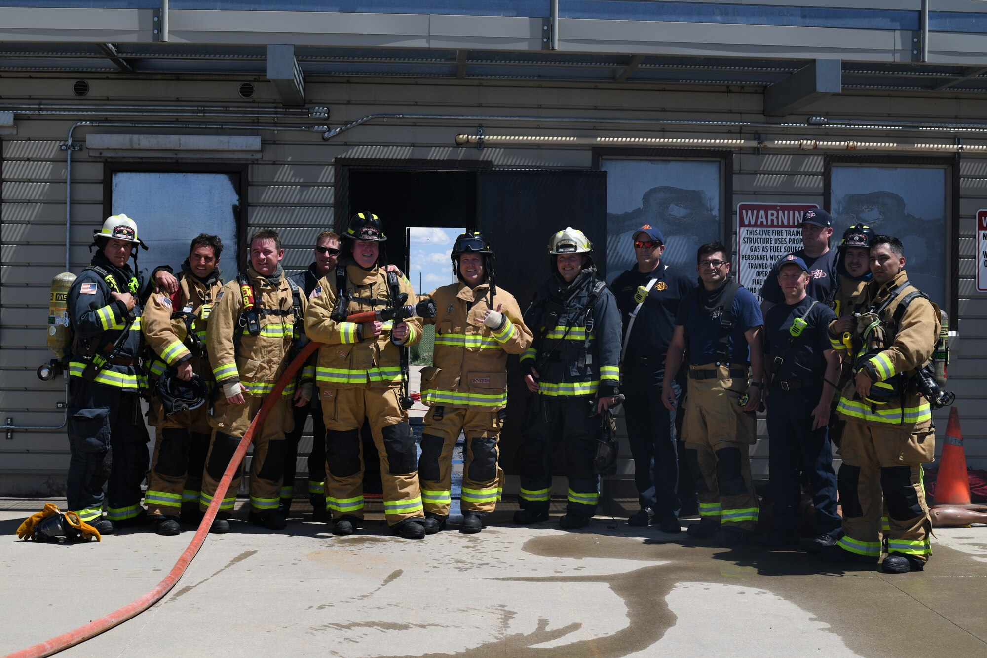 Buckley leadership and the Buckley Fire Department, stand outside the fire exercise facility, May 25, 2021, on Buckley Air Force Base, Colo. The Buckley Fire Department showed Buckley Garrison leadership what their duties may entail with a simulated two-story fire exercise. (U.S. Space Force photo by Senior Airman Michael D. Mathews)
