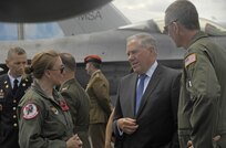 Man speaking to Air Force personnel near aircraft.