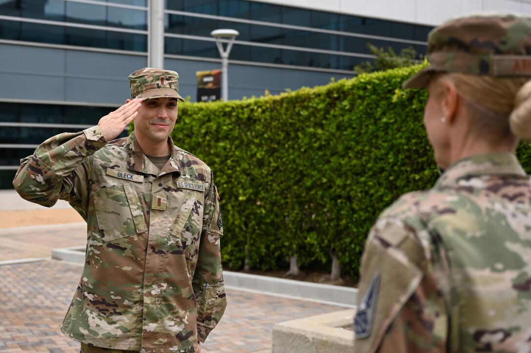 U.S. Space Force 2nd Lt. Bryan Bleck, Enterprise Corps Operations Support and Infrastructure branch product owner, renders his “first salute” to U.S. Air Force Chief Master Sgt. Lisa Arnold, Command Chief of the Space and Missiles Systems Center, May 13, 2021, Los Angeles Air Force Base, California. Prior to commissioning, 2nd Lt. Bleck worked as the superintendent for the logistics flight for the 61st Civil Engineering and Logistics Squadron at LAAFB. (U.S. Space Force photo by Staff Sgt. Andrew Moore)