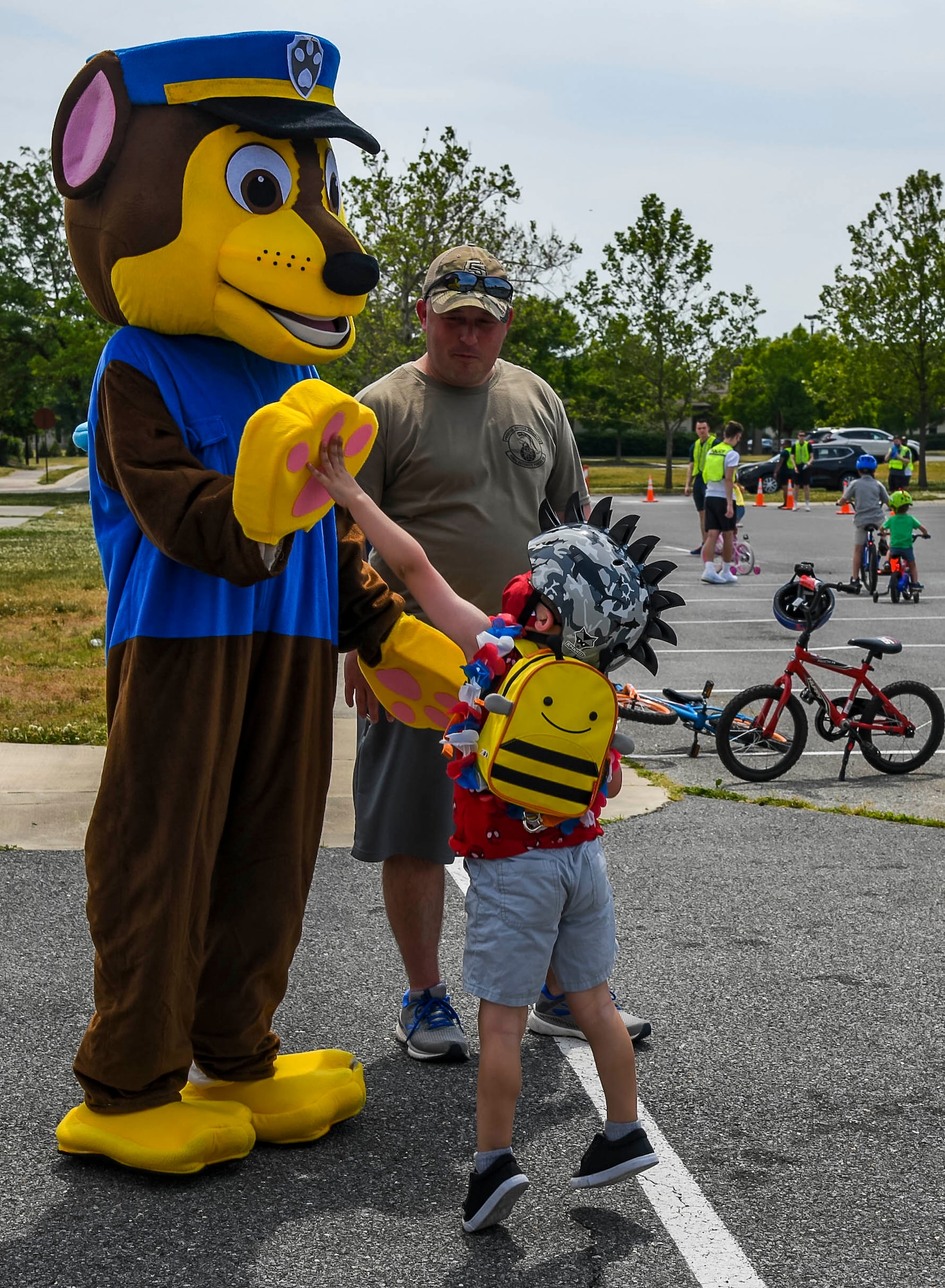 A child gives a high-five to Chase from the TV show Paw Patrol during the Bicycle Rodeo at Dover Air Force Base, Delaware, May 22, 2021. The first-of-its-kind event was created to strengthen community ties while educating base youth on safe cycling habits in a fun and interactive way. (U.S. Air Force photo by Airman 1st Class Stephani Barge)