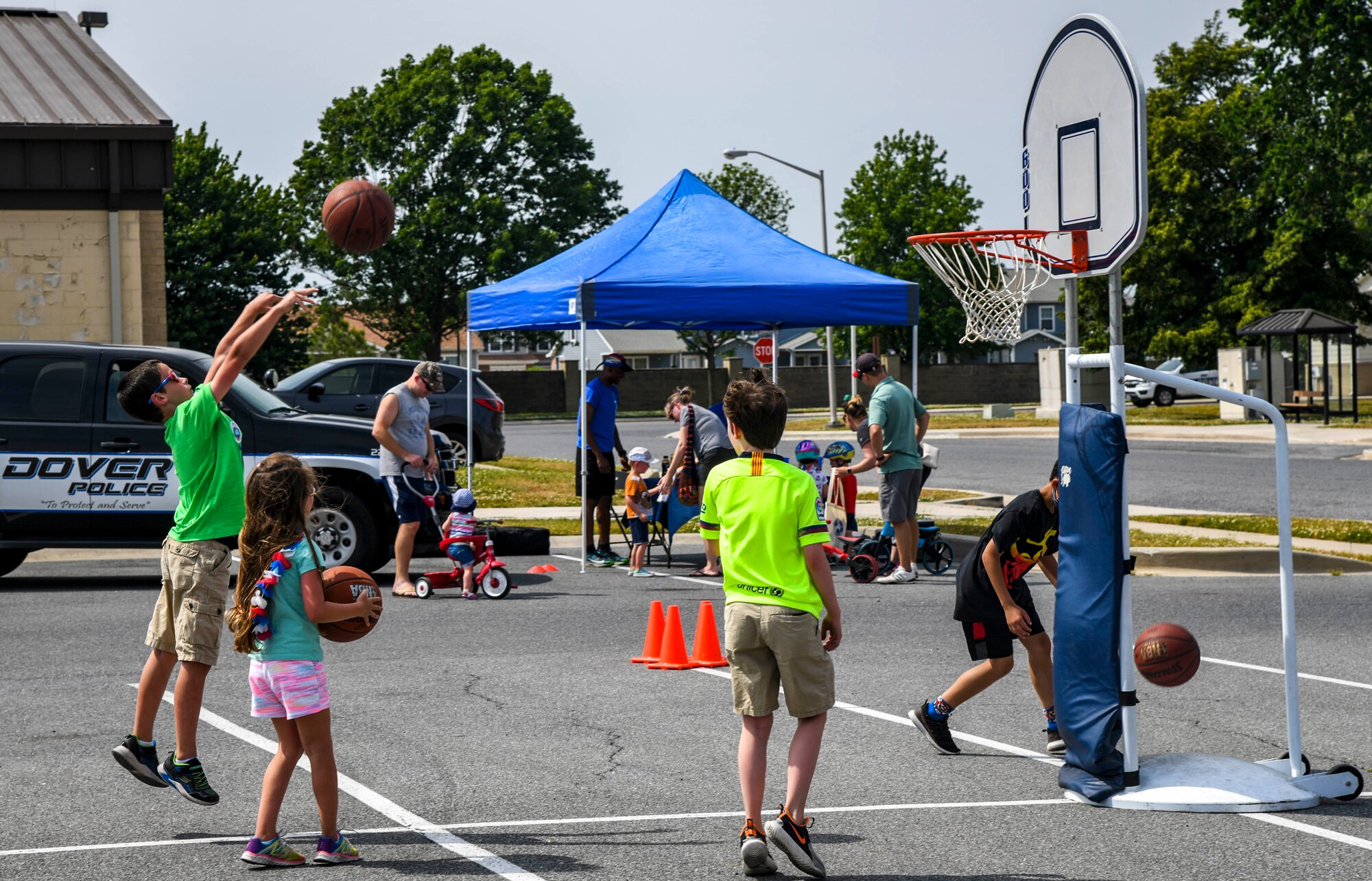 Children play basketball during the Bicycle Rodeo at Dover Air Force Base, Delaware, May 22, 2021. The Bicycle Rodeo offered a variety of attractions such as a bicycle obstacle course, Combat Arms Training and Maintenance weapon show and tell, a 436th SFS Ravens demonstration and a free raffle that provided each attending child an opportunity to win bikes, skateboards and helmets. (U.S. Air Force photo by Airman 1st Class Stephani Barge)