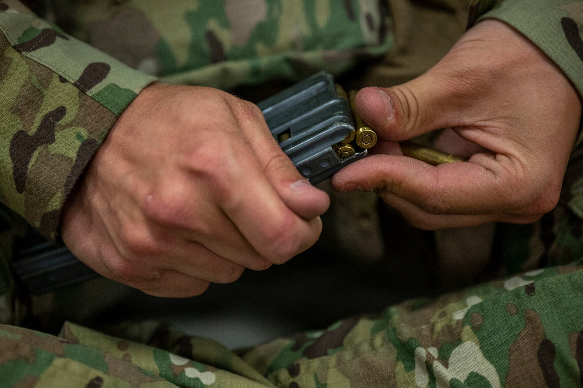 An airman from the 321st Contingency Response Squadron loads blank 5.56 NATO rounds into a magazine before a simulated Force-on-Force training event during Exercise Mobility Guardian 2021 at Alpena Combat Readiness Training Center, Michigan, May 24, 2021. Mobility Guardian tests Mobility Airmen through a challenging, realistic and detailed scenario based on relevant real-world security challenges. (U.S. Air Force photo by Senior Airman Aaron Irvin)