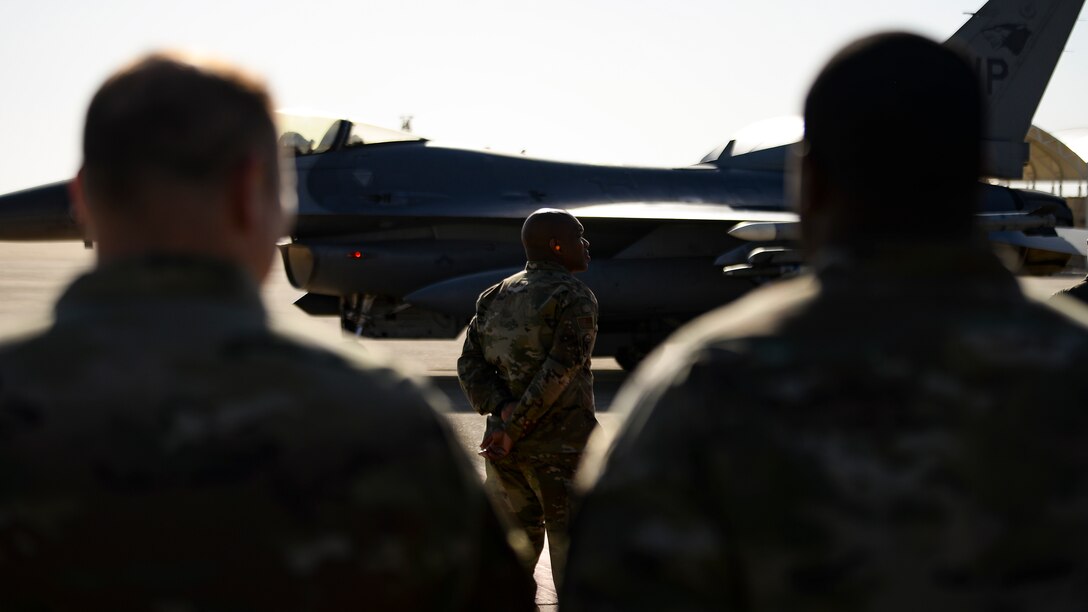 A command chief waits for his commander to exit a jet after his final flight.