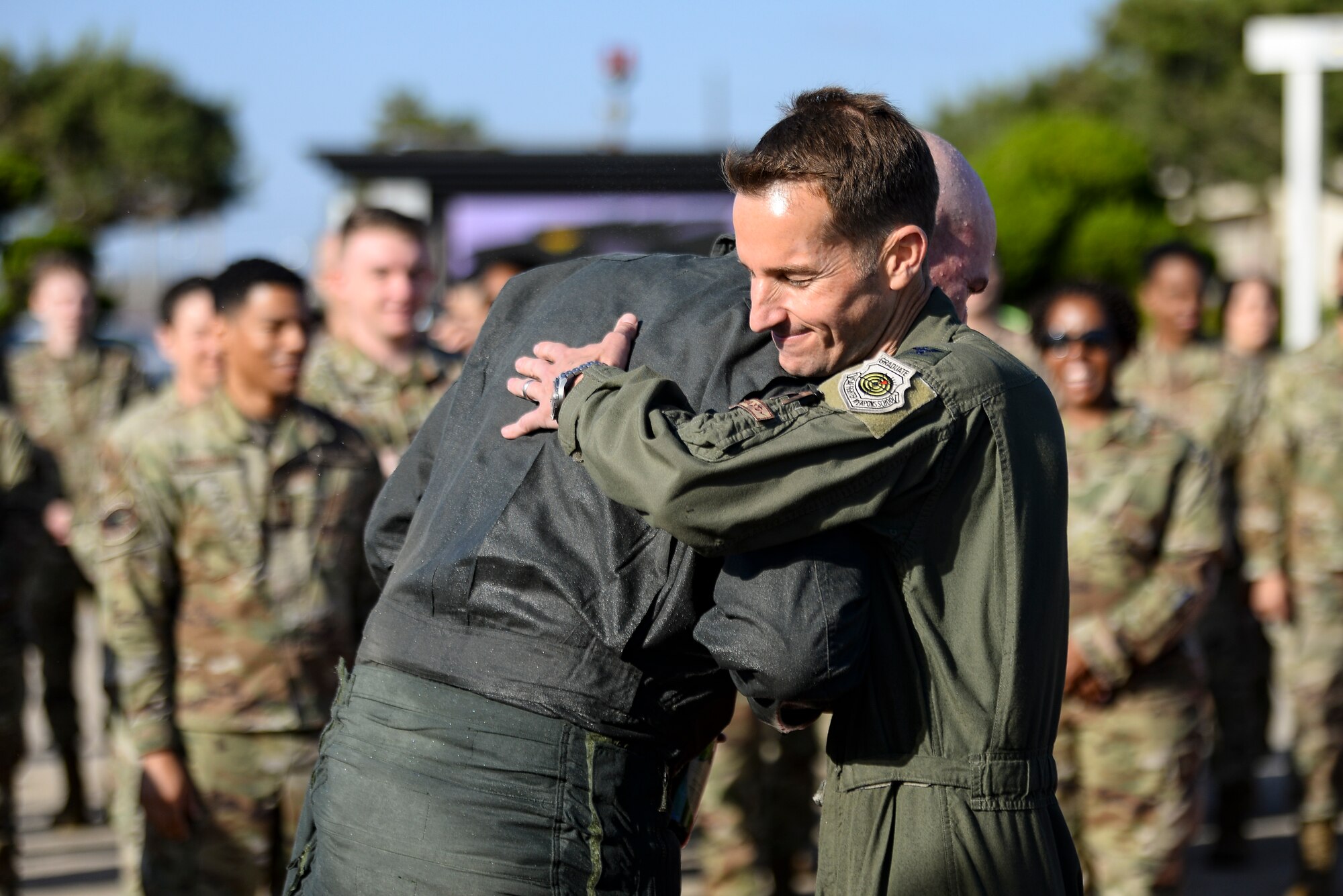 A commander hugs his vice commander after his final flight.