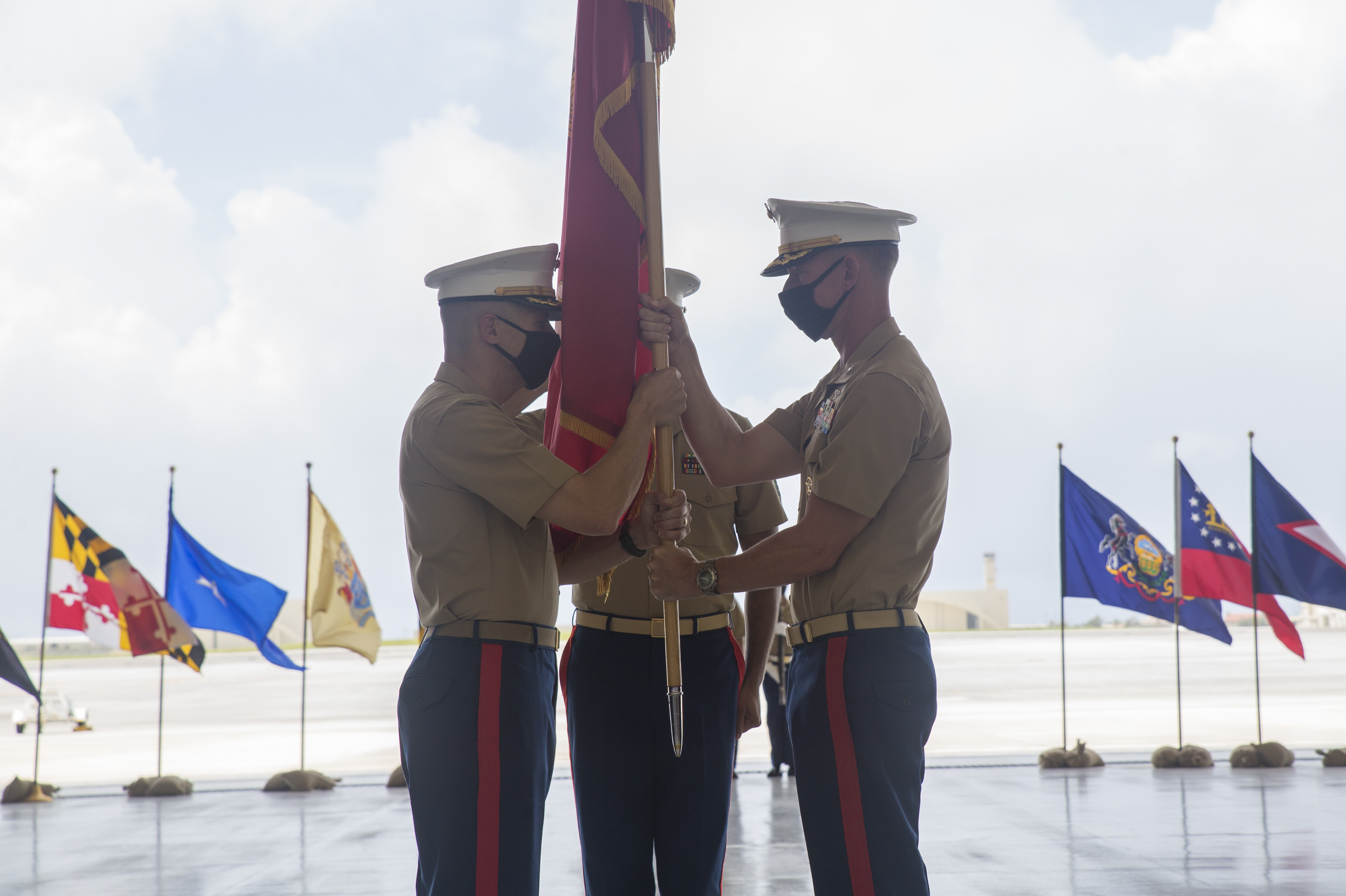 U.S. Marine Corps Col. Bradley M. Magrath, right, passes the unit colors to U.S. Marine Corps Col. Christopher L. Bopp during a change of command ceremony at the Marine Corps Base (MCB) Camp Blaz Aviation Maintenance Hangar on Andersen Air Force Base, May 7, 2021.