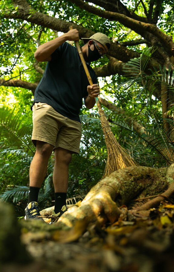 U.S. Marine Corps Cpl. Emanuel Muniz, a heavy equipment operator with 9th Engineer Support Battalion (ESB), 3d Marine Logistics Group (MLG), clean up local worship grounds around Camp Hansen, Okinawa, Japan, Mar. 10, 2021. Marines with 9th ESB took a break from their normal duties to give Kin Town residents help with cleaning up Tumusuzu Utaki, a place of worship within the Kin community. 3d MLG, based out of Okinawa, Japan, is a forward deployed combat unit that serves as III Marine Expeditionary Force’s comprehensive logistics and combat service support backbone for operations throughout the Indo-Pacific area of responsibility. (U.S. Marine Corps photo by LCpl. Sebastian Aponte)