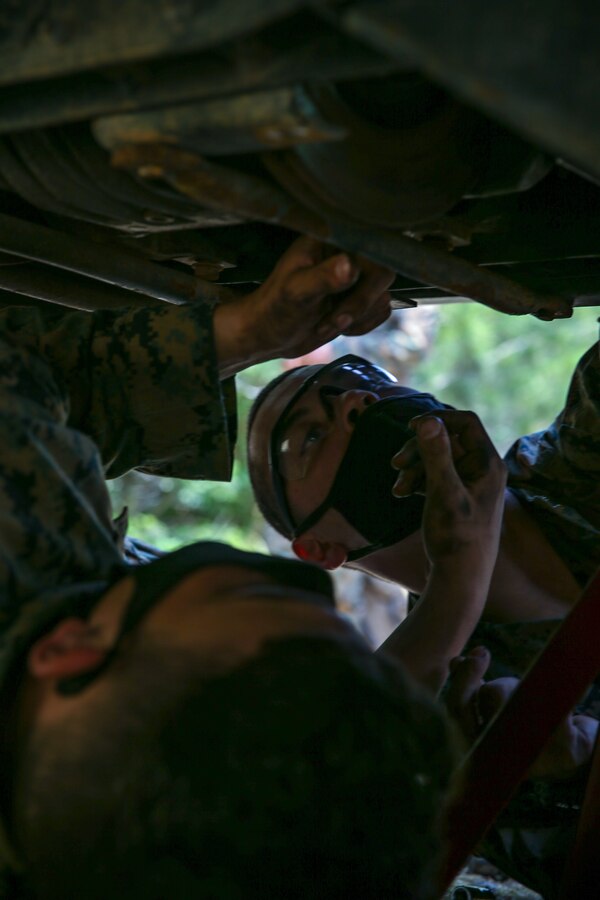 U.S. Marine Corps Pfc. Ian Allen, left, and Pfc. Andrew Crouch, both automotive maintenance technicians with Ordnance Maintenance Company (OMC), 3d Maintenance Battalion, 3d Marine Logistics Group (MLG), replace a brake pad from a High Mobility Multipurpose Wheeled Vehicle during a field maintenance exercise at Landing Zone Kiwi, Okinawa, Japan, April 20, 2021. OMC Marines regularly conduct maintenance in field settings and terrain to maintain tactical efficiency and the ability to provide support in austere environments. 3d MLG, based out of Okinawa, Japan, is a forward deployed combat unit that serves as III Marine Expeditionary Force’s comprehensive logistics and combat service support backbone for operations throughout the Indo-Pacific area of responsibility. (U.S. Marine Corps photo by Lance Cpl. Courtney A. Robertson)