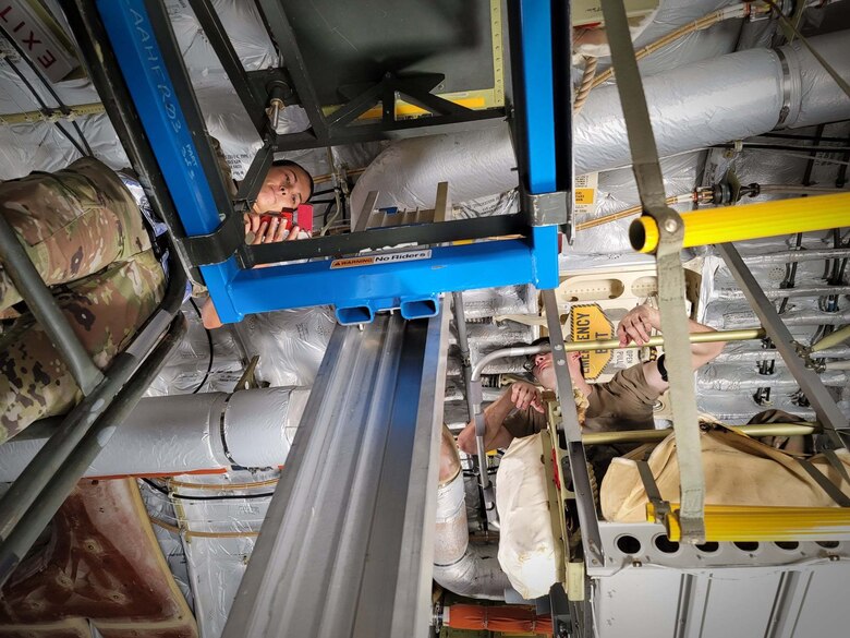 Airman 1st Class Chelsea Ecat, 154th Aircraft Maintenance Squadron crew chief, and Airman 1st Class Dylan Cartwright, 15th Maintenance Squadron crew chief, install life rafts onto a U.S. Air Force C-17 Globemaster III at Joint Base Pearl Harbor-Hickam, Hawaii, May 24, 2021. The C-17 performs tactical airlift, airdrop missions, and aeromedical evacuations.  (U.S. Air Force photo by Tech. Sgt. Anthony Nelson Jr.)