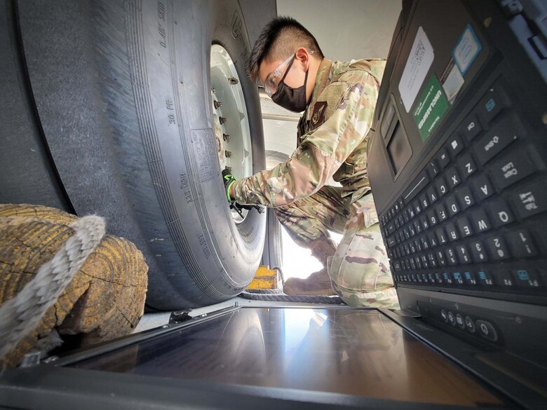 Airman 1st Class Adrian Velasquez, 15th Aircraft Maintenance Squadron crew chief, conducts a routine safety wire main landing hubcap check on a U.S. Air Force C-17 Globemaster III at Joint Base Pearl Harbor-Hickam, Hawaii, May 24, 2021. Crew chiefs ensure the aircraft are ready to fly at a moment’s notice so pilots can safely and effectively complete the mission.   (U.S. Air Force photo by Tech. Sgt. Anthony Nelson Jr.)