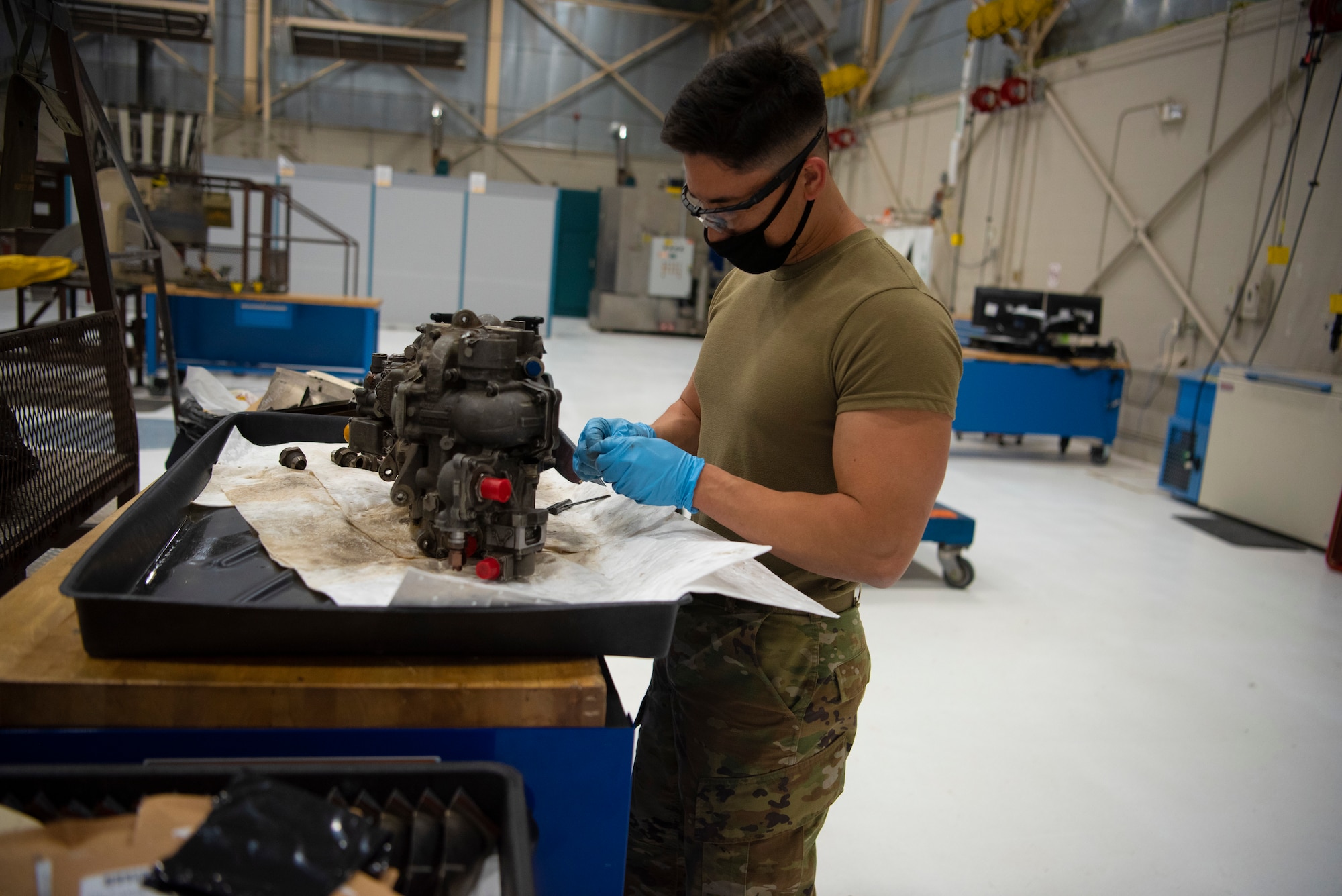 Senior Airman Noah Yoshimura, 49th Component Maintenance Squadron modular repair journeyman, cleans engine parts, May 13, 2021, on Holloman Air Force Base, New Mexico. The shop uses serviceable parts from different broken engines and pieces them together to make an engine operational. (U.S. Air Force photo by Airman 1st Class Jessica Sanchez)