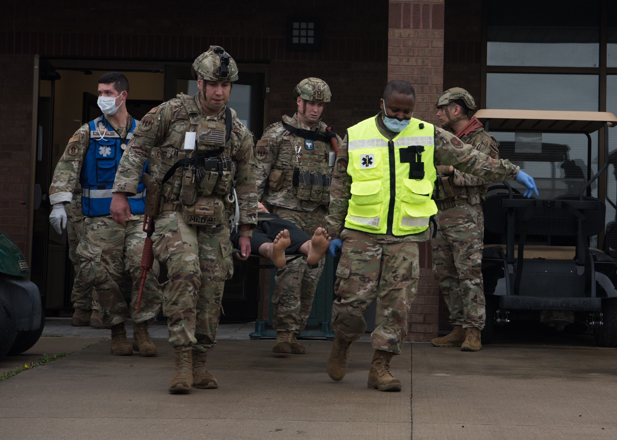 Airmen carry a simulated casualty on a stretcher.