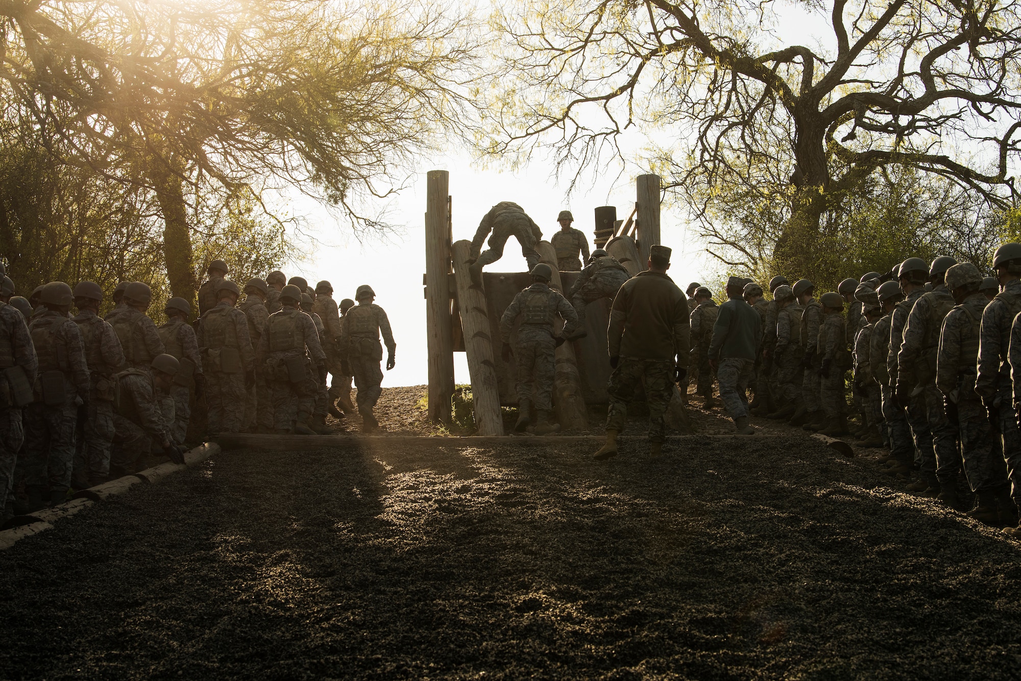 Air Force Basic Military Training trainees prepare for a log climb and rope walk obstacle during the Basic Expeditionary Airman Skills Training, a weeklong training simulation at Air Force Basic Military Training (AFBMT). The BEAST is where trainees get to put everything they've learned about combat skills into practice in a simulated environment. (U.S. Air Force photo/Bennie J. Davis III)