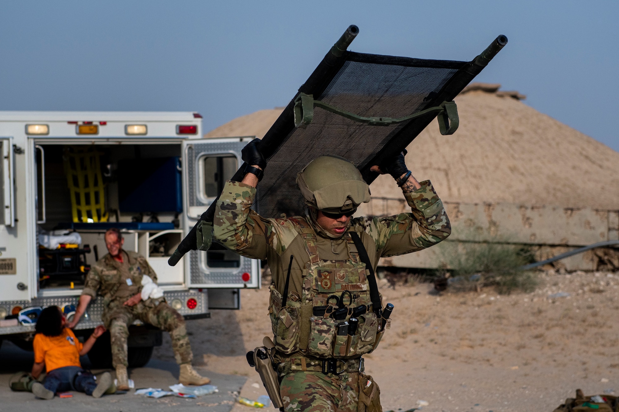 Person holding a stretcher over his head walking.