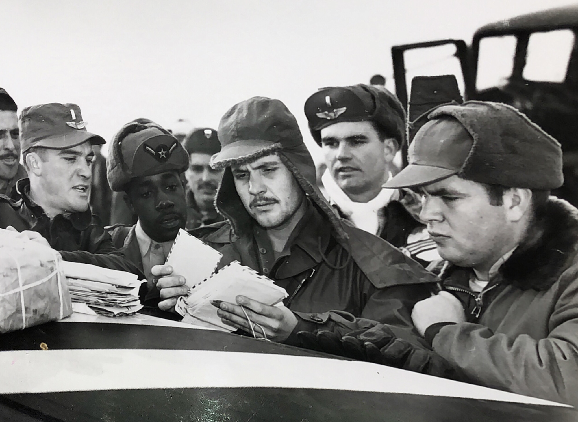 Airman gather together for "mail call" on the flight line during the Korean War. (U.S. Air Force photo)