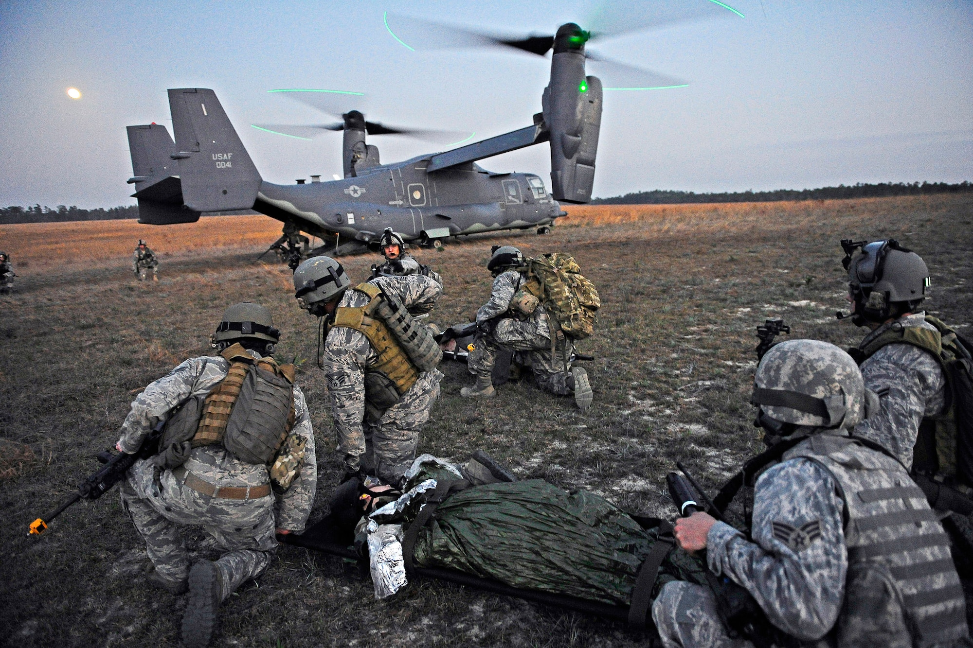 Airmen wait to load a simulated aircraft crash victim onto a CV-22 Osprey aircraft during the Emerald Warrior 2012 exercise at Hurlburt Field, Fla., March 7, 2012. Emerald Warrior is an annual two-week joint/combined tactical exercise sponsored by U.S. Special Operations Command. The exercise is designed to leverage lessons learned from operations Iraqi and Enduring Freedom to provide trained and ready forces to combatant commanders. (U.S. Air Force photo/Tech. Sgt. Charles Larkin Sr.)