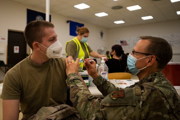 U.S. Air Force Senior Airman Bradley Frank, 435th Construction and Training Squadron command aircraft arresting systems DEPO technician, receives a COVID-19 vaccine from Senior Master Sgt. Michael Seymour, registered nurse and active Guardsman with the 603rd Air Operations Center combat operations, at Ramstein Air Base