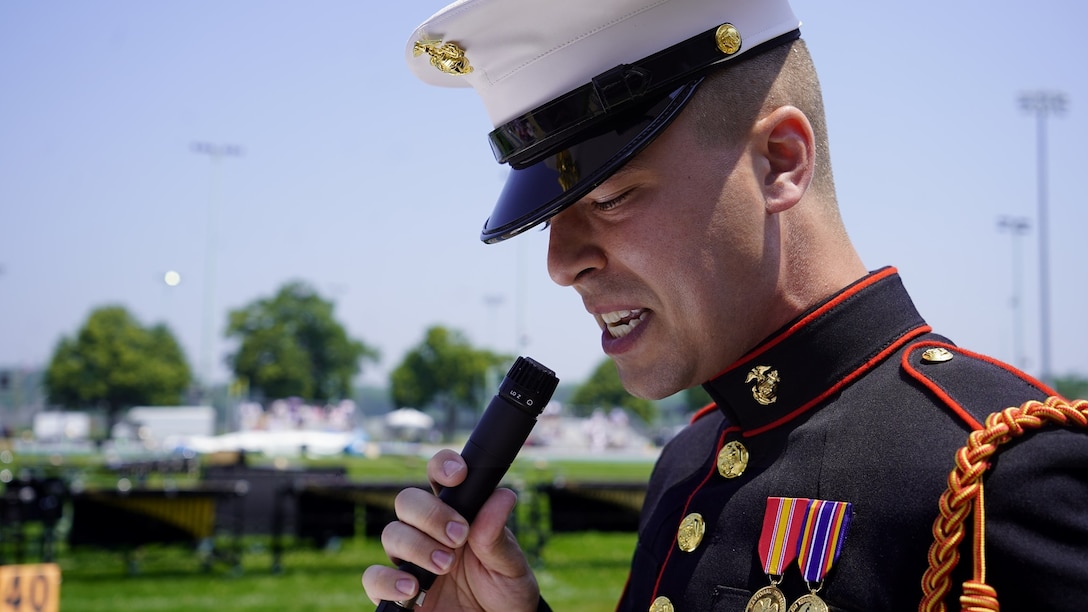 The current voice of Marine Barracks Washington, Cpl. William Liddell, narrates as Marines with “The Commandant’s Own” U.S. Marine Drum and Bugle Corps, the U.S. Marine Corps Silent Drill Platoon and the Official U.S. Marine Corps Color Guard perform during a Battle Color Ceremony as part of the U.S. Naval Academy Commissioning Week at the United States Naval Academy, Annapolis, Maryland, May 26, 2021. Parents, family members and guests of the First Class Midshipmen were invited to attend a series of events, in honor of the graduates, including an air show held by the Blue Angels. (U.S. Marine Corps photo by Sgt. Jason A. Kolela)