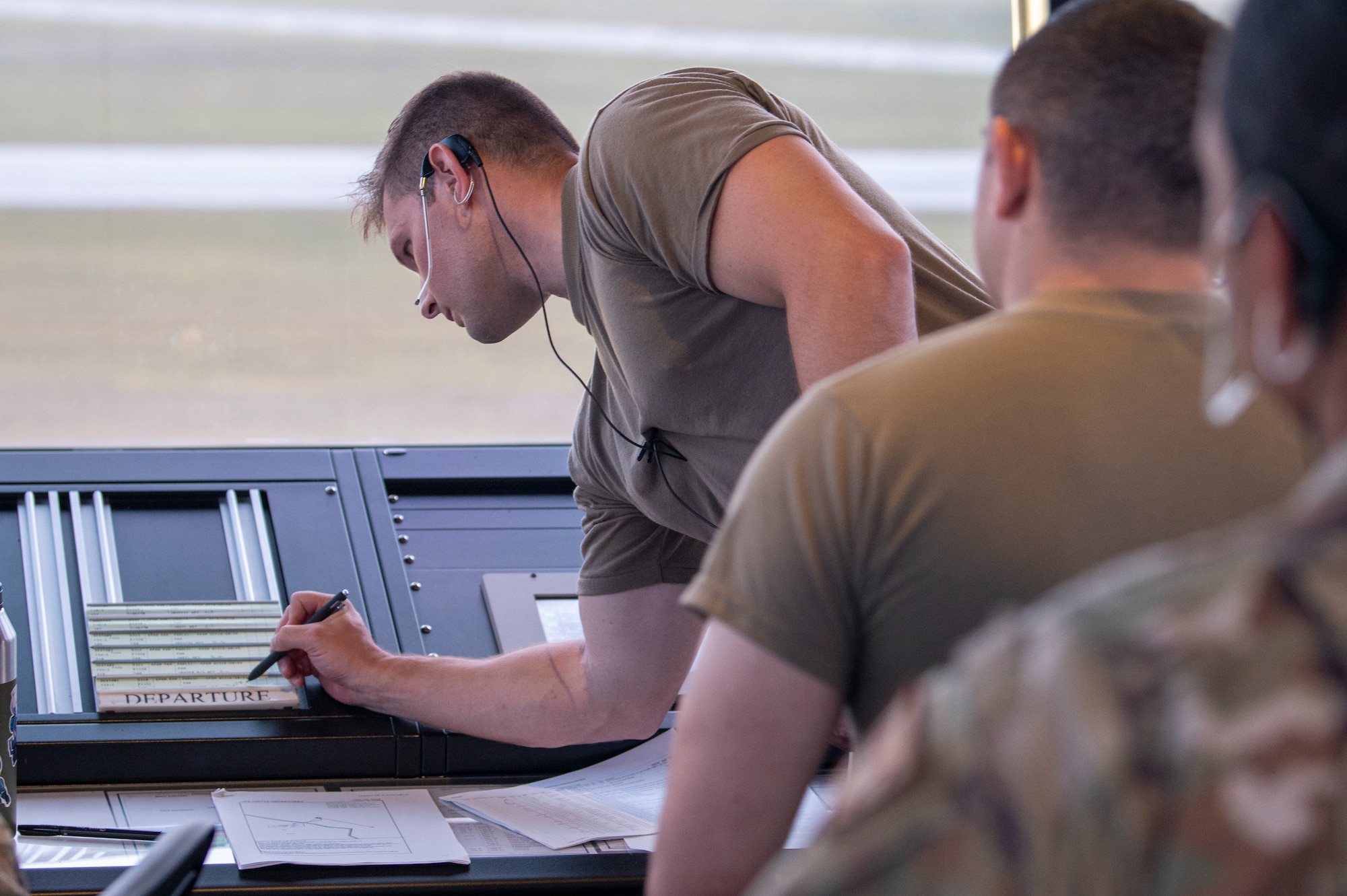 U.S. Air Force Airman checks charts in Air Traffic Control tower