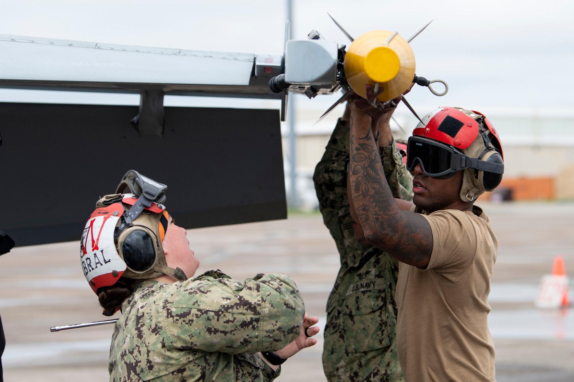 U.S. Navy Aviation Ordnancemen secure missile to an aircraft