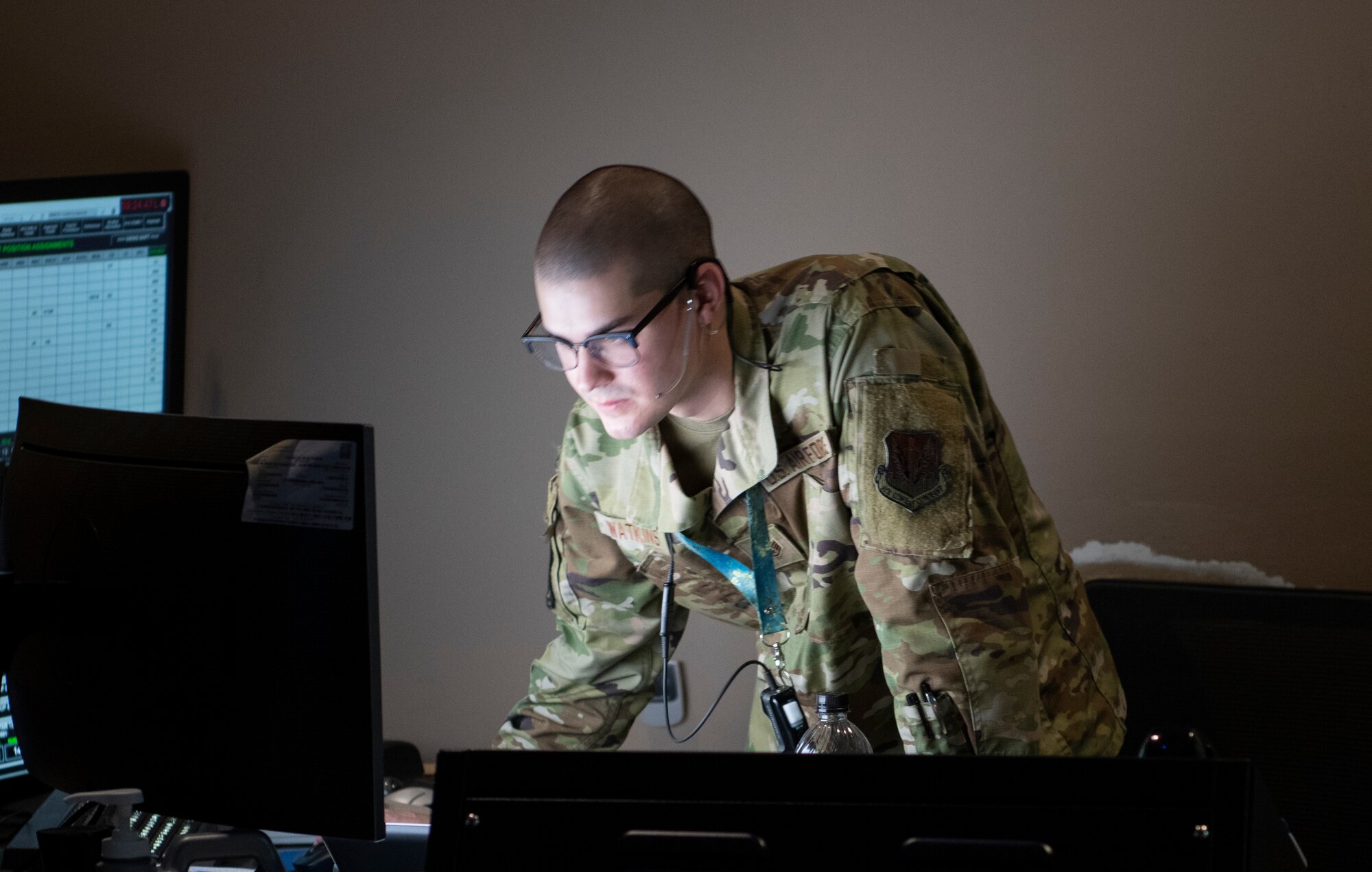 U.S. Air Force Airman stands in front of computers