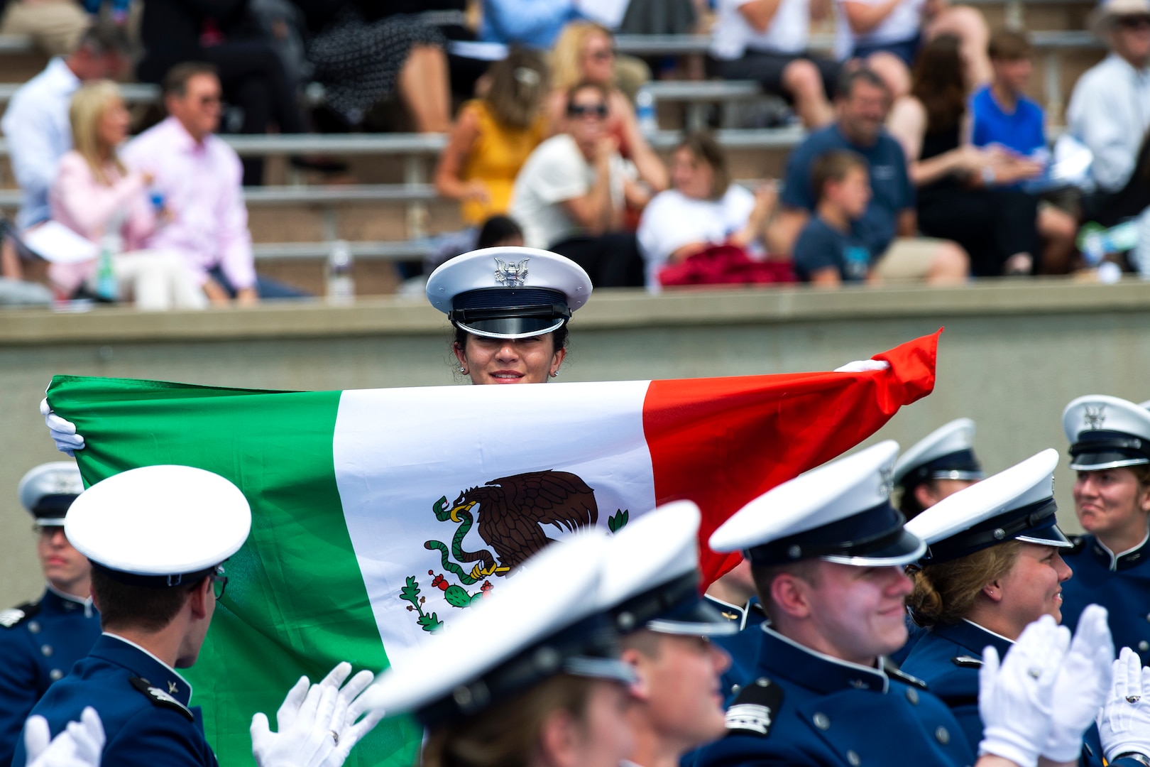 Mexican Navy Cadet Itzel Sinai Chan Topete proudly displays the Mexican flag during a graduation ceremony at the U.S. Air Force Academy, Colorado Springs, Colo., May 26, 2021.