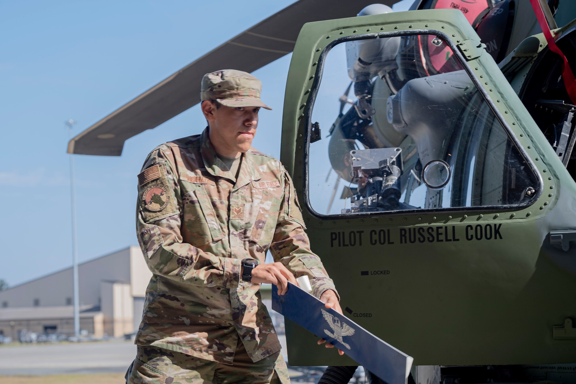 A photo of an Airman revealing a name on a helicopter
