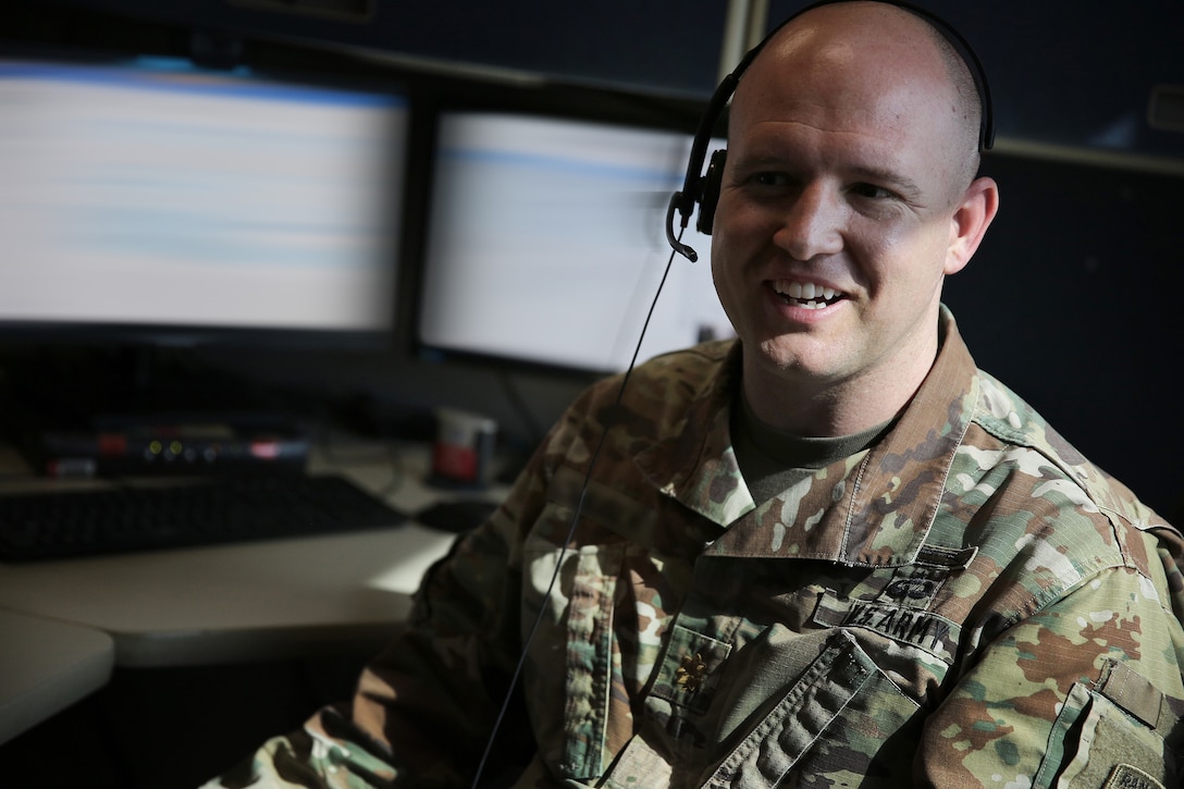 A U.S. Cyber Command, Cyber National Mission Force member talks with coworkers while attending a virtual meeting at Fort George G. Meade Md., Feb. 24, 2021.