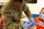 Kentucky National Guard Sgt. Okoarye Dishman, a medic, vaccinates a detainee at the Big Sandy Regional Detention Center in Paintsville, Ky., May 20, 2021.