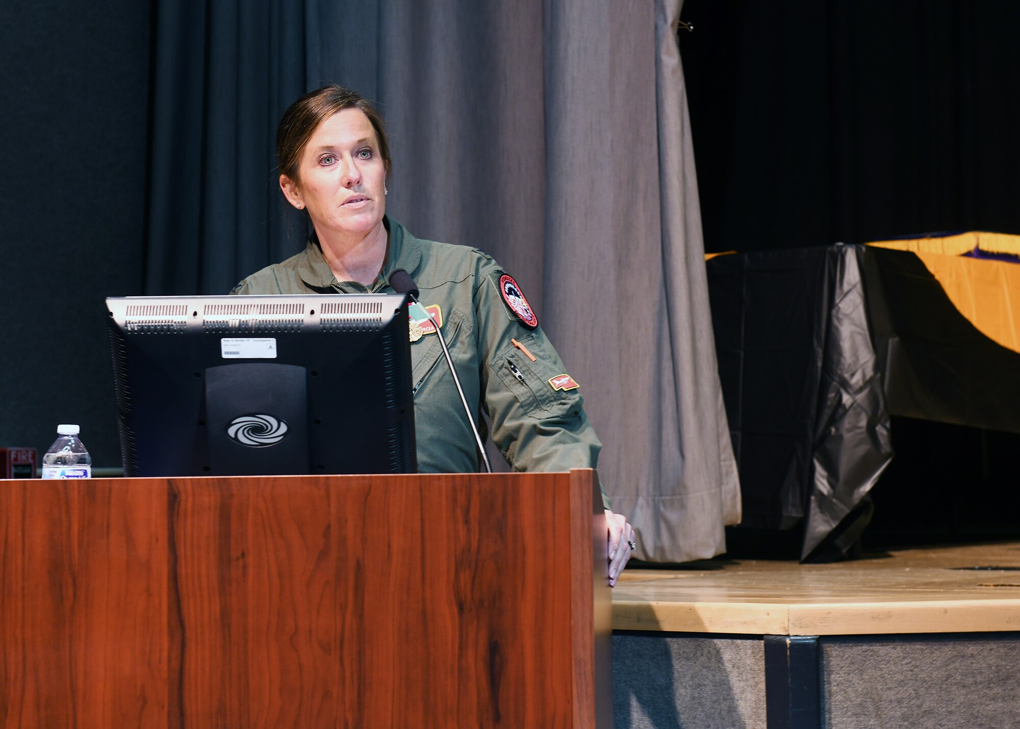 Woman military member gives her final remarks during assumption of command ceremony.
