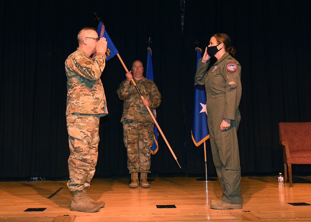 Woman military member salutes another military member after receiving the authority to lead her new military group.