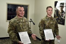 two soldiers presented with certificates.