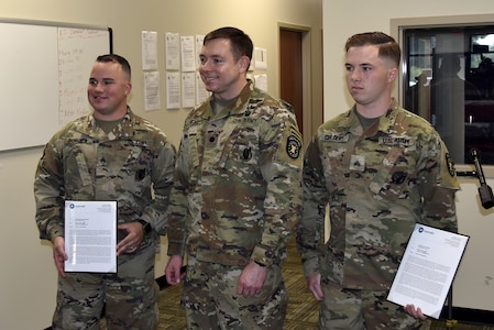 two soldiers presented with certificates.