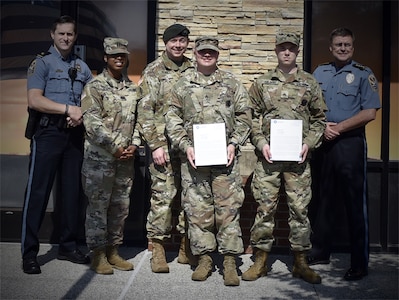 two soldiers presented with certificates.
