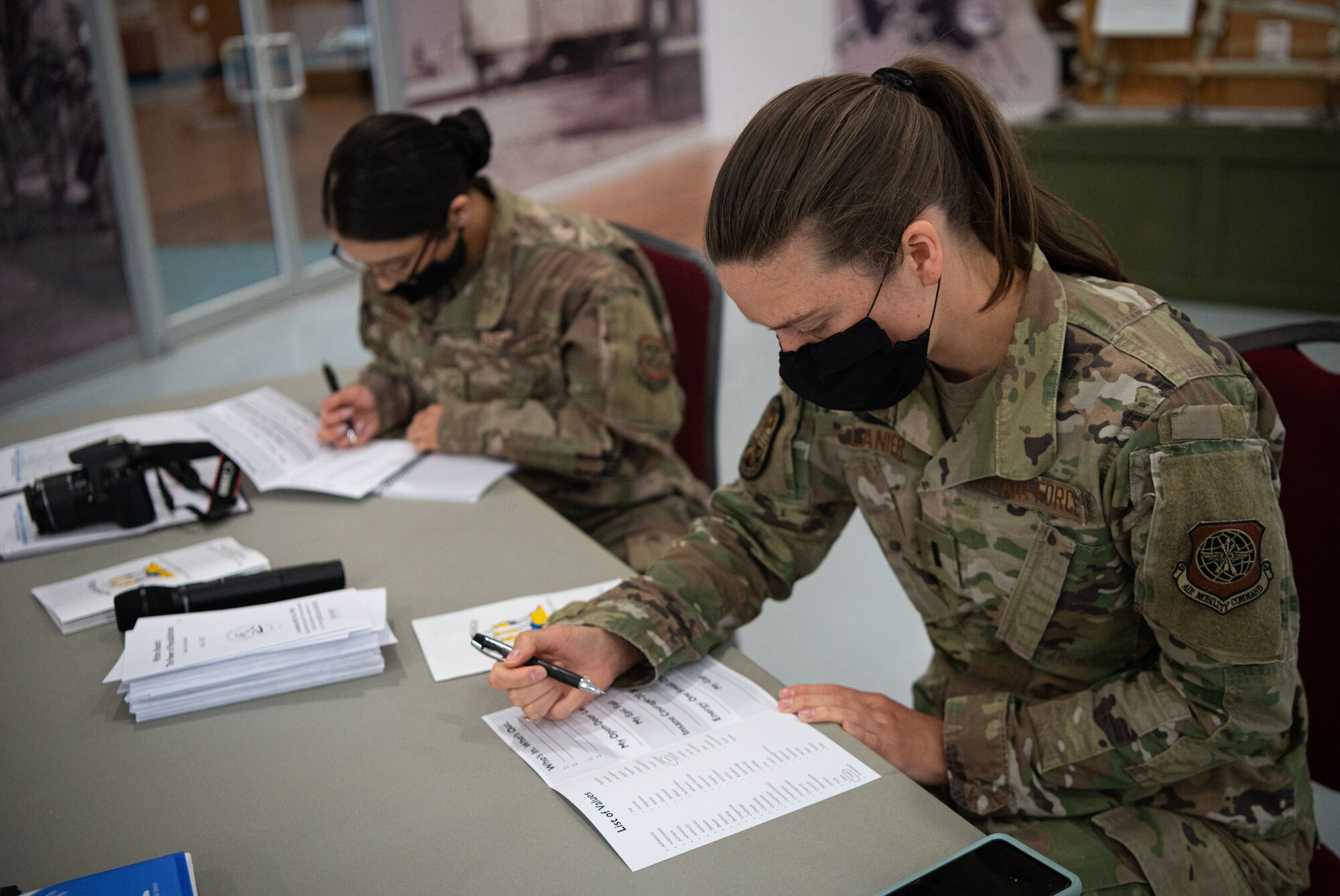 First Lt Laura Lanier, 436th Aerial Port Squadron section commander and Within Reach lecture series participant, writes in a workbook during a lecture at the Air Mobility Command Museum on Dover Air Force Base, Delaware, May 25, 2021. Jes DeShields, Ph.D., Crescent Leadership founder and principal consultant, encouraged participants to reflect on their past experiences and use them to focus on the path to success. (U.S. Air Force photo by Senior Airman Marco A. Gomez)